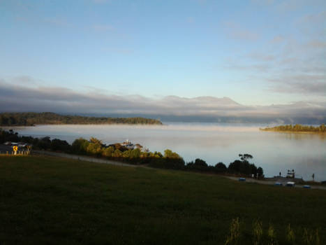 Zuidereiland - lake te anau in de optrekkende ochtendmist